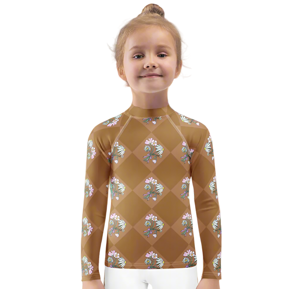 Young girl in a patterned swimsuit standing on a beach with ocean waves in the background